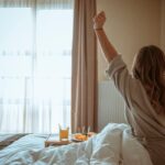 Woman relaxing and waking up in a comfortable hotel room