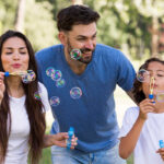 Parents and child enjoying bubble play during hotel activities