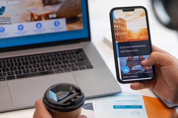 Traveler booking a hotel online using laptop and smartphone