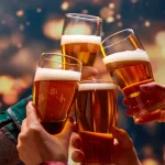 Friends clinking beer glasses and making a cheerful toast