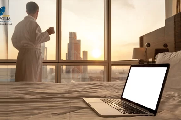 Close-up laptop on bed with man in bathrobe background