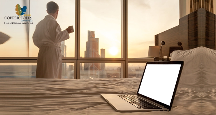 Close-up laptop on bed with man in bathrobe background