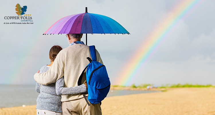 Couple walking on Calicut beach with umbrella during rain